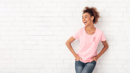 Breast Cancer. African American Woman Wearing Pink T-Shirt With Ribbon Symbol Posing Over White Wall. Free Space