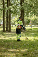 Lawn mowers cut the grass in a city park.