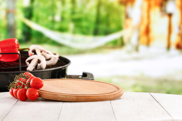 Grilled vegetables on white wooden garden table with blurred garden background. Grilling concept and copy space for products.