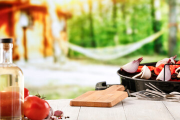 Grilled vegetables on white wooden garden table with blurred garden background. Grilling concept and copy space for products.