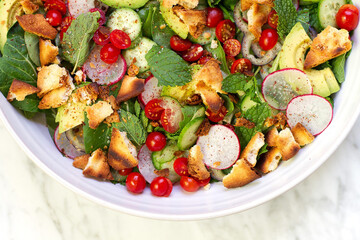 Fresh healthy vegetable Mediterranean salad of feta cheese, tomato, olives, green pepper and green basil leaves