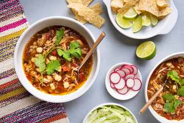 SPICY MEXICAN CHICKEN AND POBLANO POZOLE, A HOT SOUP OR STEW TRADITIONALLY TOPPED WITH CILANTRO, CABBAGE AND RADISHES