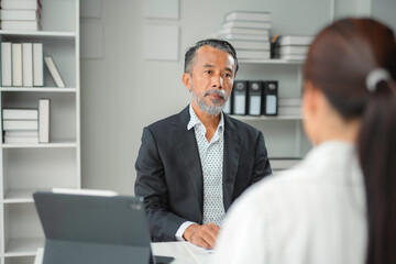 Fototapeta premium Experienced businessman listening attentively to a colleague during a meeting in a modern office