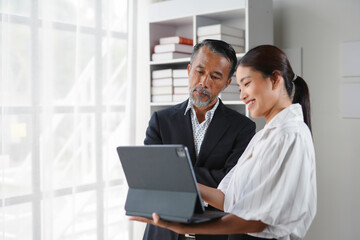 Asian business team collaborating on a project using a digital tablet in the office