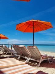 Relaxing by the Blue Waters: Red Umbrella and Beach Chairs