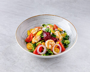 Salad with shrimps in sweet and sour sauce with mango and avocado. on a gray background