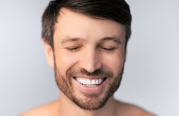 Middle Aged Man Smiling With Closed Eyes Posing Over White Background In Studio. Shallow Depth,...