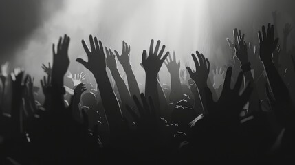 crowd of people with their hands raised in the dark hall