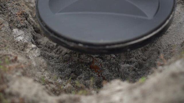 He runs a mine detector over the found mine