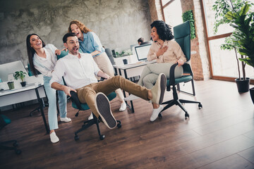 Photo of ride armchair have fun teamwork young people working together employees modern industrial open space style interior workplace