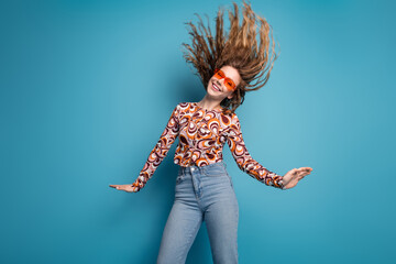 Photo of nice young girl dancing flying hair wear top isolated on blue color background