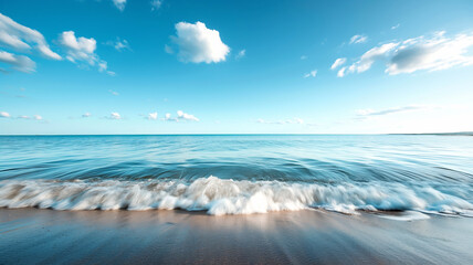 The calm ocean waves gently lap against the sandy shore under a clear blue sky.