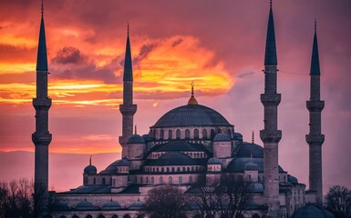 Obraz premium A serene mosque with its minarets silhouetted against a sunset