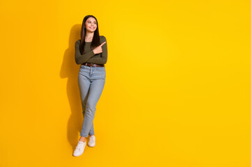 Full size photo of pretty teenager girl point look empty space wear trendy khaki outfit isolated on yellow color background