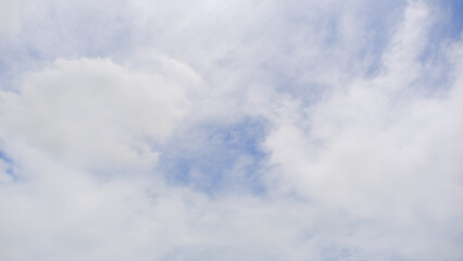 Fototapeta premium Serene sky with soft, fluffy clouds and bright blue patches, perfect for backgrounds or nature-themed projects.