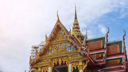 Fototapeta premium Stunning architecture of a traditional Thai temple with intricate details and vibrant colors against a clear blue sky.
