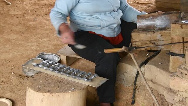 Ban Napia, Laos - 15th january, 2024: laotian people make aluminum spoons from Vietnam war era munition remains or UXO. Collect UXO , melt down in kiln and fashion it to spoons household items