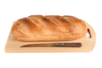 Cutting board with a fresh loaf of bread and a bread knife on a white background.