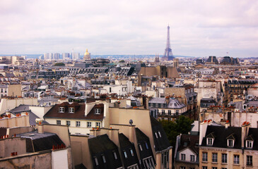Fototapeta premium A panoramic view from the top of the Centre Pompidou of the Eiffel Tower in the distance and the surrounding districts. Panorama of Paris, France