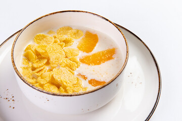 Cereals with milk with orange slices in a plate