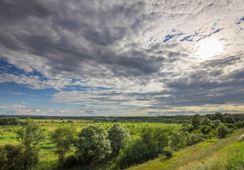A cloudy sky with a sun peeking through the clouds
