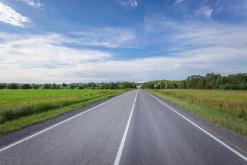 A long, empty road with a clear blue sky above