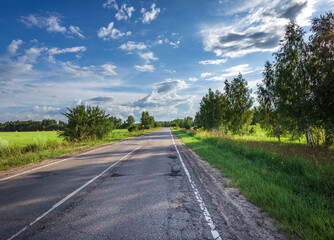 A road with trees on either side and a clear blue sky