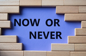 Now or Never symbol. Concept words Now or Never on wooden blocks. Beautiful purple background. Business and Now or Never concept. Copy space