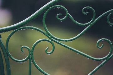 Rain Droplets on Green iron chair detail.  vintage metal fence. abstract metallic background. Rainy...
