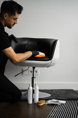 Cleaning dark leather chair with a soft brush and detergent. Dealing with stains and dust on...