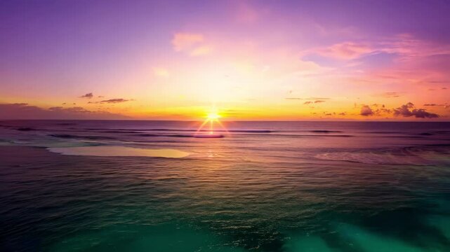 A beautiful sunset paints the sky with vibrant colors as the sun dips below the horizon, casting a warm glow over the calm ocean waves.