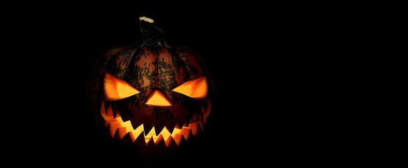 Fototapeta premium Halloween pumpkin with scary face on black background.
