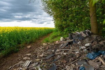 Pile of Trash Near Rapeseed Field on  Cloudy Day