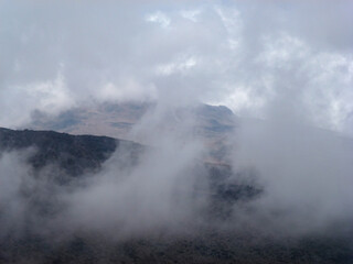 View of the slope of a large mountain covered with a white cloud. Beautiful summer landscape for climbing and hiking