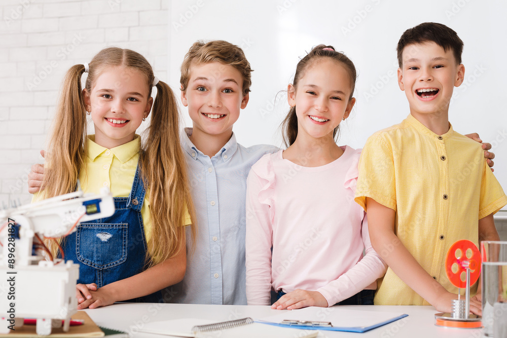 Aufkleber four young students, two boys and two girls, are smiling and working on a science experiment in a cl