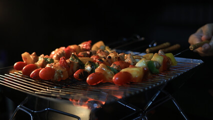 A woman prepares ingredients and prepares BBQ. Grilling for the party in the night. A woman is getting ingredients ready and grilling BBQ for a party at night.