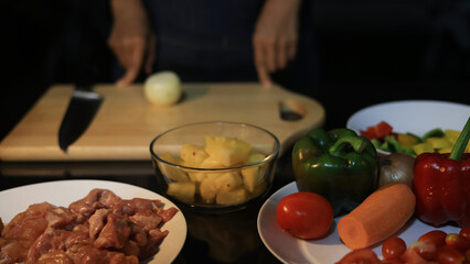A woman prepares ingredients and prepares BBQ. Grilling for the party in the night. A woman is getting ingredients ready and grilling BBQ for a party at night.