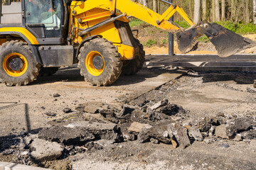 Yellow Excavator Removing Asphalt During Road Construction