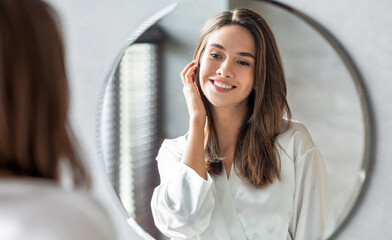 Beauty Concept. Portrait Of Attractive Happy Woman Looking At Mirror In Bathroom, Beautiful...