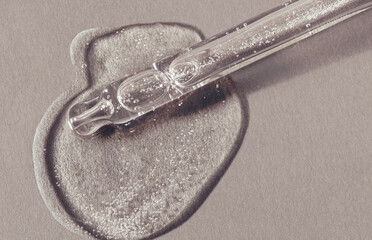 Liquid gel or serum gray transparent on a screen of microscope gray paper background