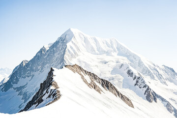 Obraz premium Majestic Snow-Capped Mountain Peak Against a Clear Blue Sky