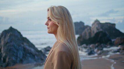 Fashion model posing sunset beach at cloudy sky. Closeup sexy blonde in suit