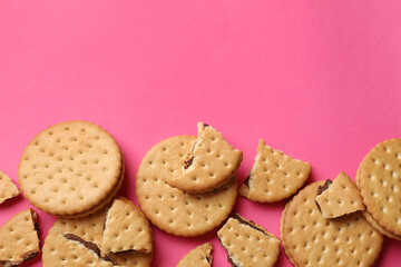 Tasty sandwich cookies on pink background, top view. Space for text