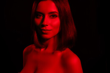 Portrait of girl look in camera isolated over red light dark color background