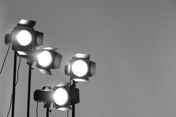 Grey photo background and professional lighting equipment in studio. Space for text
