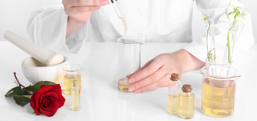 Aromatherapy product. Scientist developing essential oils at white table in laboratory, closeup