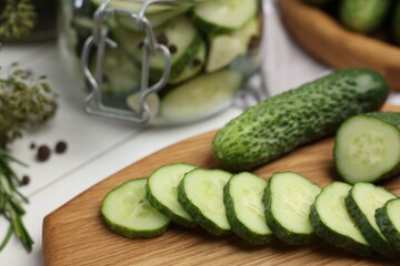 Board with fresh cut cucumber on light table, closeup. Preparation for pickling
