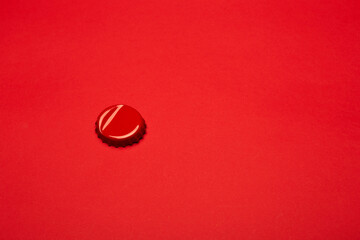 Оpened wrinkled bent red color beer bottle crown cap lid isolated on the bright solid fond plain...