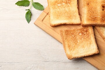 Slices of delicious toasted bread on wooden table, top view. Space for text