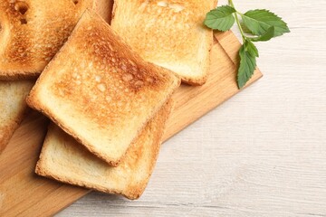Slices of delicious toasted bread on wooden table, top view
